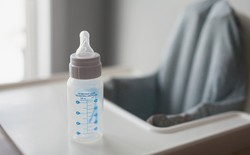 Baby bottle on top of high-chair table.