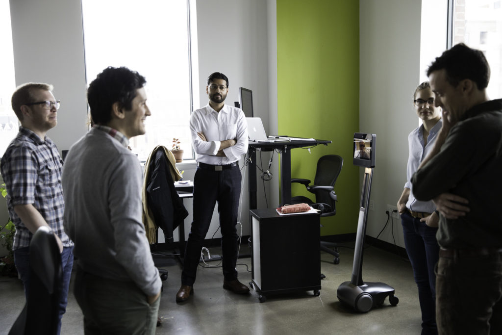 Coworkers standing in a circle talking